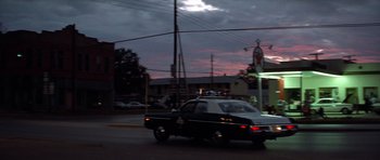 Movie still from “The Sugarland Express” (1974), directed by Steven Spielberg – A police car driving down a street at night; Wide shot, Low angle