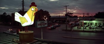Movie still from “The Sugarland Express” (1974), directed by Steven Spielberg – A neon chicken sign on the side of the road; Extreme Wide shot, Low angle