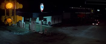 Movie still from “The Sugarland Express” (1974), directed by Steven Spielberg – An empty gas station at night with no one in it; Extreme Wide shot, High angle