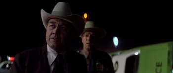 Movie still from “The Sugarland Express” (1974), directed by Steven Spielberg – Two men in suits and hats standing next to each other; Close Up shot, Over the shoulder angle