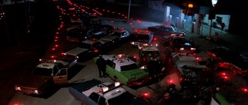 Movie still from “The Sugarland Express” (1974), directed by Steven Spielberg – An aerial view of a city street at night with police cars; Extreme Wide shot, High angle