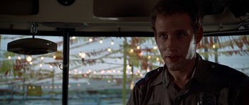 Movie still from “The Sugarland Express” (1974), directed by Steven Spielberg – A man in a uniform standing in the driver's seat of a car; Close Up shot, Over the shoulder angle