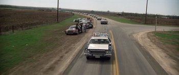 Movie still from “The Sugarland Express” (1974), directed by Steven Spielberg – Several cars parked on the side of a road; Wide shot, High angle