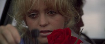Movie still from “The Sugarland Express” (1974), directed by Steven Spielberg – A person holding a red rose; Close Up shot, High angle