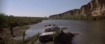 Movie still from “The Sugarland Express” (1974), directed by Steven Spielberg – A car that is sitting in the water near a body of water; Extreme Wide shot, High angle