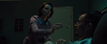 Movie still from “The Super” (2017), directed by Stephan Rick – A woman is holding a spoon in her hand; Medium shot, Low angle