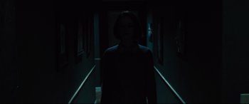 Movie still from “The Super” (2017), directed by Stephan Rick – A woman standing in a dark hallway in the dark; Wide shot, High angle