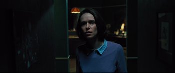 Movie still from “The Super” (2017), directed by Stephan Rick – A person standing in a room with a light on; Medium shot, Over the shoulder angle