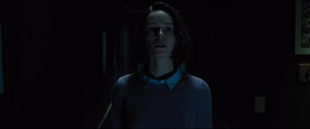 Movie still from “The Super” (2017), directed by Stephan Rick – A woman standing in a dark room with her eyes wide open; Medium shot, Low angle