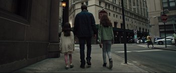 Movie still from “The Super” (2017), directed by Stephan Rick – A man and two girls walking down a street; Wide shot, Low angle