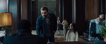 Movie still from “The Super” (2017), directed by Stephan Rick – A group of people standing around a room; Medium shot, Over the shoulder angle