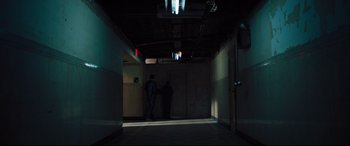 Movie still from “The Super” (2017), directed by Stephan Rick – Two people are standing in a dark hallway; Extreme Wide shot, High angle