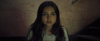 Movie still from “The Super” (2017), directed by Stephan Rick – A young girl with long dark brown hair and green eyes; Close Up shot, High angle