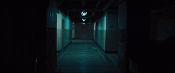 Movie still from “The Super” (2017), directed by Stephan Rick – A dark hallway with lights hanging from the ceiling; Extreme Wide shot, High angle