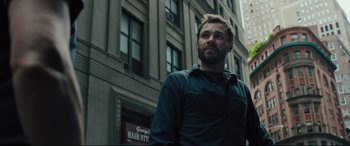 Movie still from “The Super” (2017), directed by Stephan Rick – A man standing in front of a tall building in the city; Close Up shot, Low angle