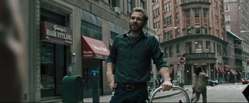 Movie still from “The Super” (2017), directed by Stephan Rick – A man is standing on the sidewalk with his bike; Medium shot, Over the shoulder angle