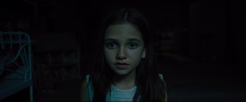Movie still from “The Super” (2017), directed by Stephan Rick – A young girl with long dark hair stares into the camera; Close Up shot, High angle