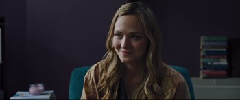 Movie still from “The Super” (2017), directed by Stephan Rick – A woman with long blonde hair sitting in a chair; Close Up shot, Over the shoulder angle