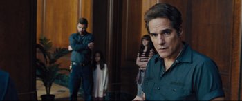 Movie still from “The Super” (2017), directed by Stephan Rick – A group of people standing in a room; Medium shot, Over the shoulder angle