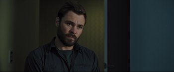 Movie still from “The Super” (2017), directed by Stephan Rick – A man with a goatee is looking at the camera; Close Up shot, Over the shoulder angle