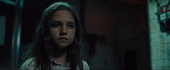 Movie still from “The Super” (2017), directed by Stephan Rick – A young girl is staring into the camera; Close Up shot, Low angle