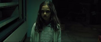 Movie still from “The Super” (2017), directed by Stephan Rick – A young girl is standing in a dark room; Close Up shot, High angle