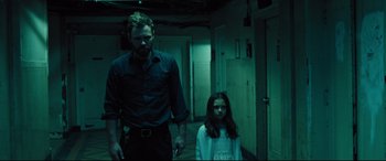 Movie still from “The Super” (2017), directed by Stephan Rick – A man and a little girl standing in a hallway; Medium shot, Low angle