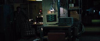 Movie still from “The Super” (2017), directed by Stephan Rick – An old computer sitting on top of a desk; Wide shot, High angle
