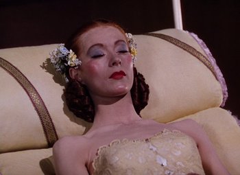Movie still from “The Tales of Hoffmann” (1951), directed by Michael Powell – A woman with red hair laying on top of a couch; Close Up shot, High angle
