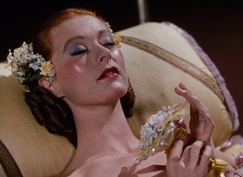 Movie still from “The Tales of Hoffmann” (1951), directed by Michael Powell – A beautiful woman laying on top of a bed; Close Up shot, High angle