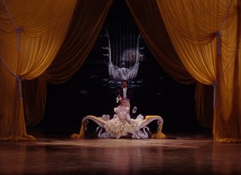 Movie still from “The Tales of Hoffmann” (1951), directed by Michael Powell – A man and a woman sitting on a stage; Wide shot, High angle