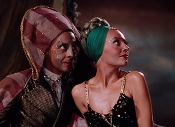 Movie still from “The Tales of Hoffmann” (1951), directed by Michael Powell – A man and a woman dressed in costumes; Medium shot, Low angle