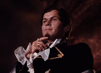 Movie still from “The Tales of Hoffmann” (1951), directed by Michael Powell – A person wearing a suit and tie; Close Up shot, Low angle