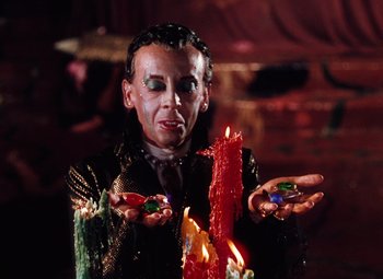 Movie still from “The Tales of Hoffmann” (1951), directed by Michael Powell – A man in a costume holding candles in his hands; Medium shot, High angle