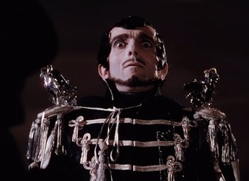 Movie still from “The Tales of Hoffmann” (1951), directed by Michael Powell – A man in a black and white outfit with a bunch of keys around his neck; Close Up shot, Low angle
