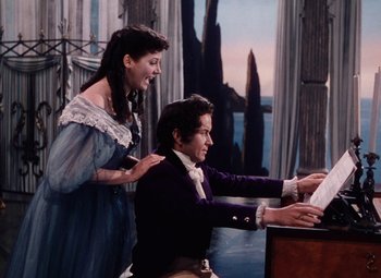 Movie still from “The Tales of Hoffmann” (1951), directed by Michael Powell – A man and a woman are playing the piano; Medium shot, High angle