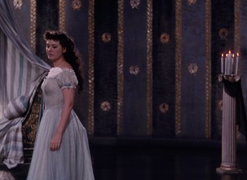 Movie still from “The Tales of Hoffmann” (1951), directed by Michael Powell – A man and a woman dressed in a dress; Wide shot, High angle