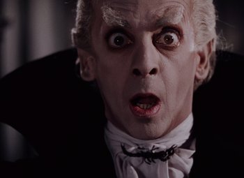 Movie still from “The Tales of Hoffmann” (1951), directed by Michael Powell – A person wearing a suit and tie; Close Up shot, Low angle