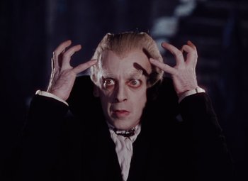 Movie still from “The Tales of Hoffmann” (1951), directed by Michael Powell – A person wearing a suit and tie; Close Up shot, Low angle