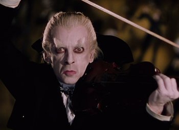 Movie still from “The Tales of Hoffmann” (1951), directed by Michael Powell – A person wearing a suit and tie; Close Up shot, Low angle