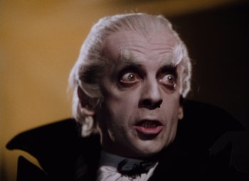 Movie still from “The Tales of Hoffmann” (1951), directed by Michael Powell – An old man with white hair wearing a black suit; Close Up shot, Low angle