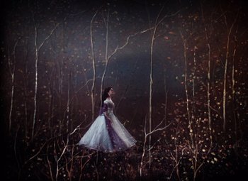 Movie still from “The Tales of Hoffmann” (1951), directed by Michael Powell – A painting of a woman in a dress in the woods; Wide shot, Low angle