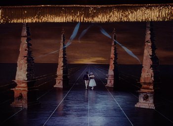 Movie still from “The Tales of Hoffmann” (1951), directed by Michael Powell – Two people are standing in the middle of an empty stage; Extreme Wide shot, High angle