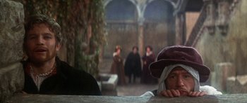 Movie still from “The Taming of The Shrew” (1967), directed by Franco Zeffirelli – A group of people sitting at a table in a room; Medium shot, Over the shoulder angle