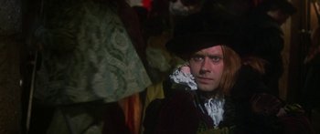 Movie still from “The Taming of The Shrew” (1967), directed by Franco Zeffirelli – A man wearing a black hat and a red coat; Close Up shot, Over the shoulder angle
