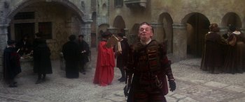 Movie still from “The Taming of The Shrew” (1967), directed by Franco Zeffirelli – An old man dressed in medieval clothing in a courtyard; Medium shot, Low angle