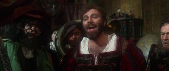 Movie still from “The Taming of The Shrew” (1967), directed by Franco Zeffirelli – A man with a long beard and a hat on; Medium shot, Over the shoulder angle
