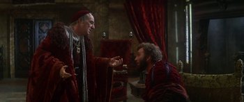 Movie still from “The Taming of The Shrew” (1967), directed by Franco Zeffirelli – Two men in medieval garb talking to each other; Medium shot, Over the shoulder angle