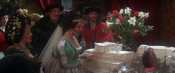 Movie still from “The Taming of The Shrew” (1967), directed by Franco Zeffirelli – A group of people standing next to a cake; Medium shot, High angle