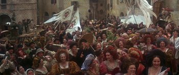 Movie still from “The Taming of The Shrew” (1967), directed by Franco Zeffirelli – A group of people in costumes in a crowd; Extreme Wide shot, High angle